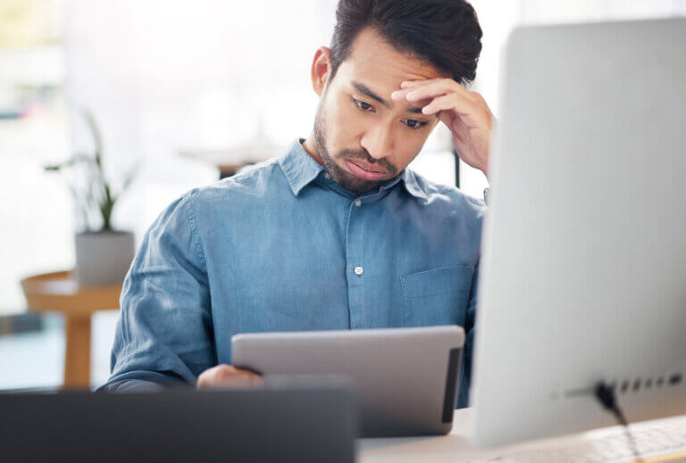 Stressed out and confused actor looking down at his tablet after spotting a red flag.