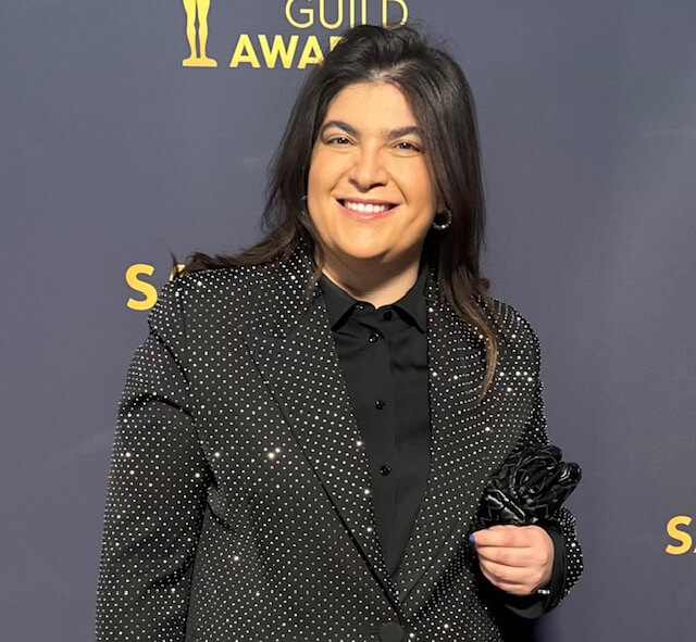Talent Agent Gaby Cohen smiling in a jackaet on the red carpet of an award show.