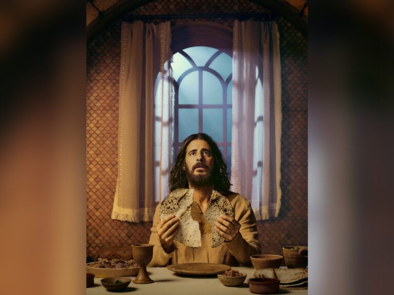 Actor Jonathan Roumie breaking breat at the head of the table as Jesus Christ in television series The Chosen.